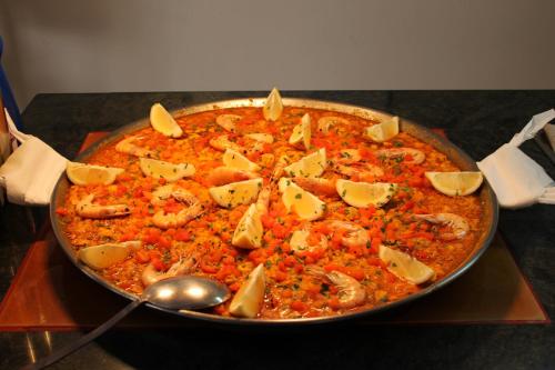 a pan of food with shrimp and cheese on a table at Brasilia in Chipiona