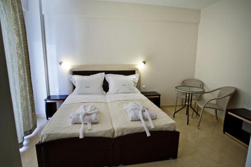 1 dormitorio con 1 cama con toallas en Rg Status Hotel, en Paralia Katerinis