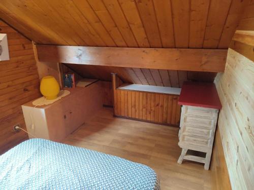 a small attic room with a bed and a desk at haut de chalet le Bois de Cerf in Les Angles