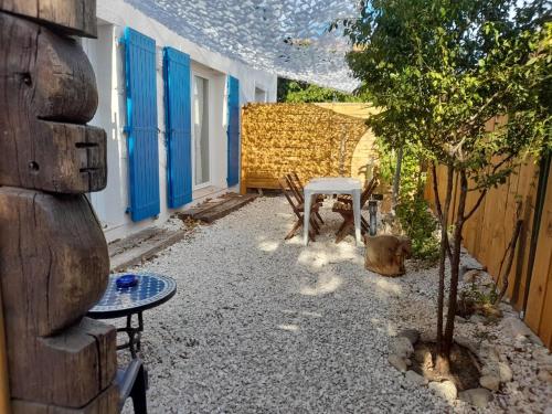 a small patio with a table and a tree at La Locomotive in Sausset-les-Pins