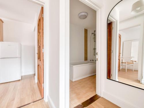 a white room with a mirror and a kitchen at Pass the Keys Stylish 2 Bed Apartment Parking Oxford in Oxford