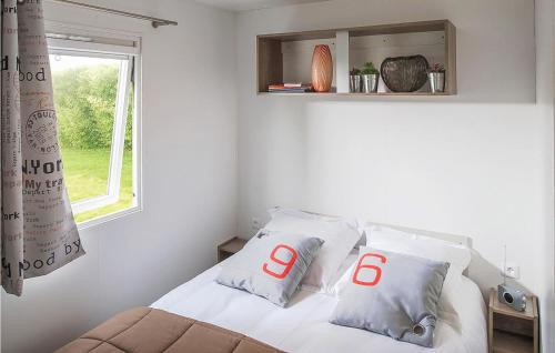 ein Schlafzimmer mit einem Bett mit zwei Kissen mit den Buchstaben o in der Unterkunft Stunning Home In Hvide Sande With House A Panoramic View in Hvide Sande