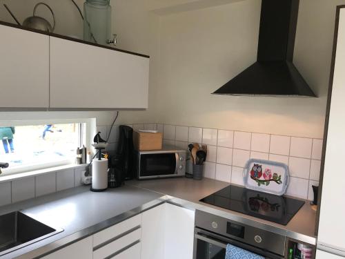 a kitchen with white cabinets and a stove top oven at Mysig lillstuga Köpingsvik - Öland in Köpingsvik