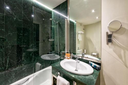 a bathroom with two sinks and a glass shower at Mariposa Hotel Malaga in Málaga