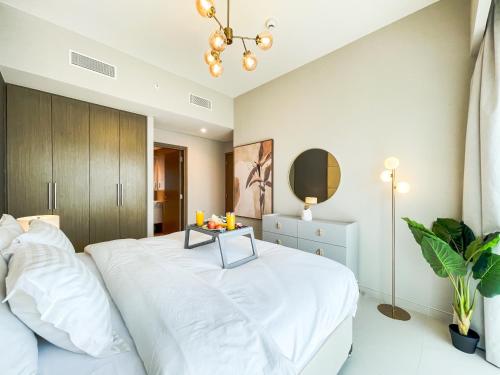 Un dormitorio con una cama blanca y una mesa. en Amazing apartment next to Dubai Mall 160BR-2 en Dubái
