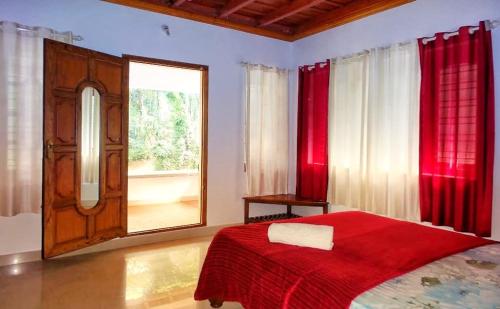 a bedroom with a red bed and a window at Coorg devine spark in Madikeri