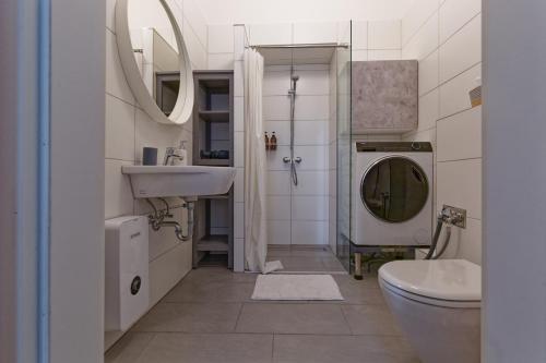 a bathroom with a sink and a toilet and a mirror at Apartment near Warschauer Platz and Spree river in Berlin