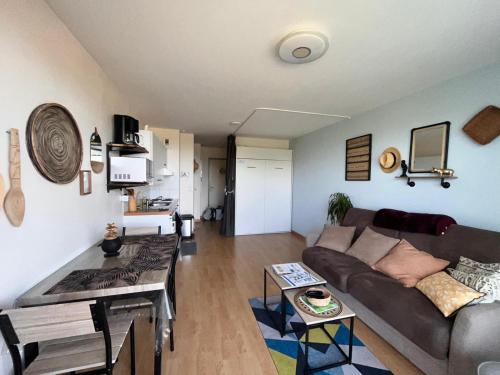 a living room with a couch and a table at Les pieds dans le sable in Malo-les-Bains