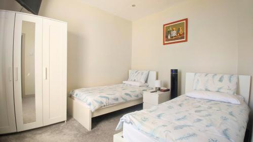 a bedroom with two beds and a mirror at Modern holiday let in Skipton, North Yorkshire in Skipton