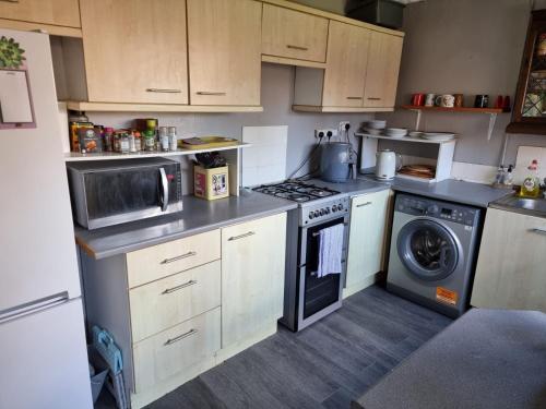 a kitchen with a stove and a washing machine at 31 Elwyn Road in March
