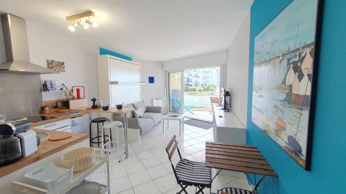 une cuisine et un salon avec une table et des chaises dans l'établissement Grand Bleu-Studio vue sur mer - piscine, à Les Sables-dʼOlonne