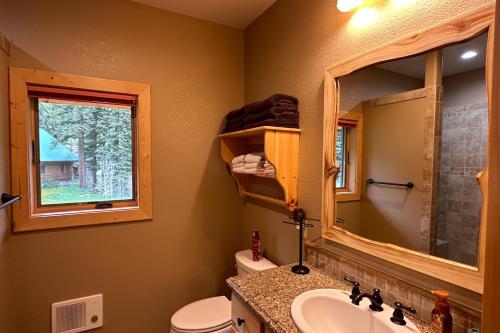 y baño con aseo, lavabo y espejo. en Scenic Solitude, en South Fork
