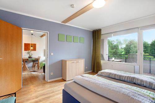 1 dormitorio con 2 camas y balcón en Kleine Auszeit en Brilon