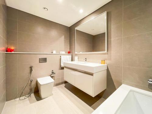 bagno con lavandino, servizi igienici e specchio di Amazing apartment next to Dubai Mall 160BR-2 a Dubai