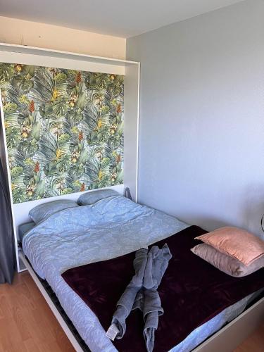 a bedroom with a bed with a large mural on the wall at Les pieds dans le sable in Malo-les-Bains
