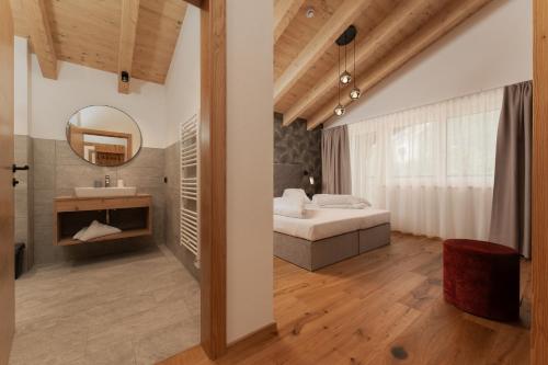 - une chambre avec un lit et un miroir dans l'établissement A CASA Amethyst, à Sölden
