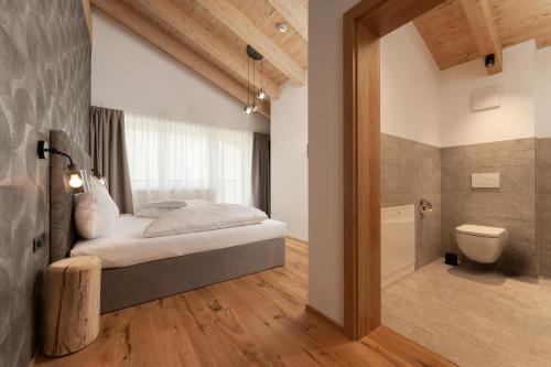 a bedroom with a bed and a bathroom with a toilet at A CASA Amethyst in Sölden