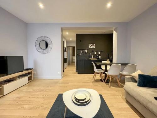 un salon avec un canapé et une table dans l'établissement Appart DELAVIGNE spacieux classé 4 étoiles parking privatif, à Aix-les-Bains