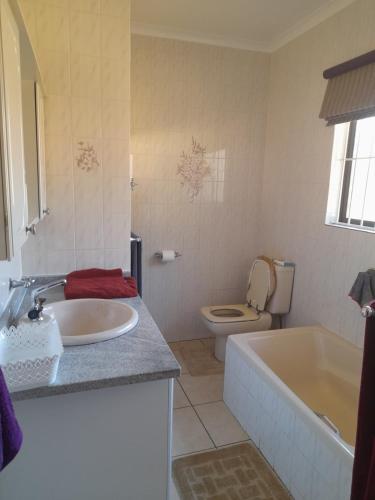 a bathroom with a tub and a toilet and a sink at Chappel Hide Out in Germiston