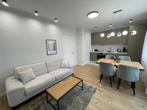 a living room with a white couch and a table at Vanquish Central Apartment in Varna City