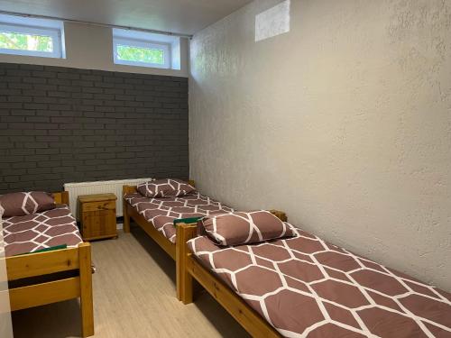 拉塞尼艾的住宿－Hostel Vytista，带三张床和砖墙的房间