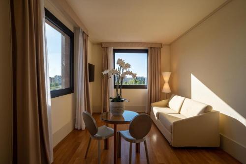 salon z kanapą i stołem z krzesłami w obiekcie Hilton Garden Inn Florence Novoli we Florencji