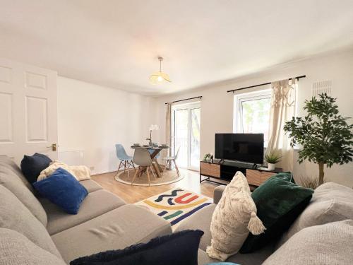 a living room with a couch and a tv at BEAUTIFUL WINDSOR 2 BED, PERFECT LOCATION, 5 Mins Walk to Centre, Private Gated Parking, Legoland, Ascot in Windsor