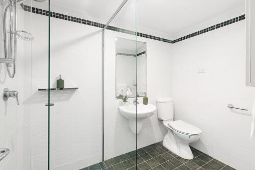 a bathroom with a toilet and a glass shower at King Bedroom Waterfront Courtyard Apartment in Sylvania