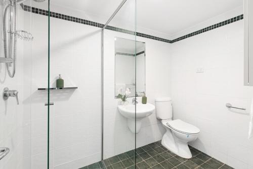 SylvaniaKing Bedroom Waterfront Courtyard Apartment的带马桶和玻璃淋浴间的浴室