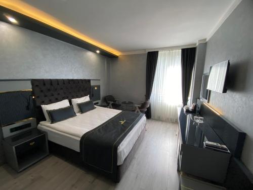 a hotel room with a large bed and a desk at alfin otel in Ankara