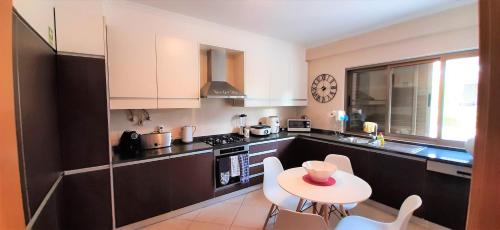 a kitchen with a small table and chairs in it at Apartment in the center of Tavira with swimming pool and garage in Tavira
