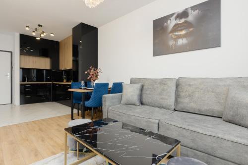a living room with a couch and a table at Warsaw Kotsisa Apartments with Parking by Renters in Warsaw