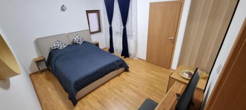 a bedroom with a bed with a blue blanket at Casa Merci in Cîmpulung