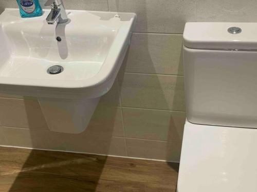 a white sink and a toilet in a bathroom at April Disc - Long Stay - Contractors in Mangotsfield