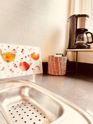 - un comptoir de cuisine avec un évier et une boîte dans l'établissement Le Petit Bijou Hyper centre Sedan, à Sedan