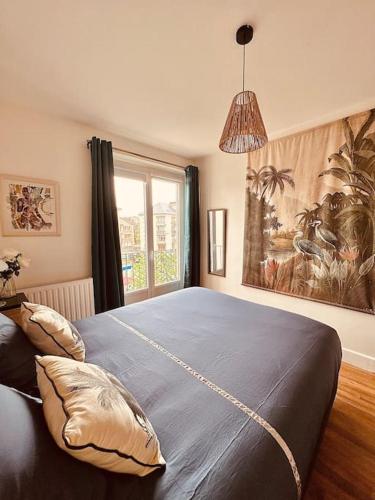 une chambre avec un grand lit avec une grande fenêtre dans l'établissement Le Petit Bijou Hyper centre Sedan, à Sedan