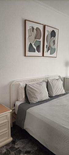 sypialnia z łóżkiem z trzema zdjęciami na ścianie w obiekcie Gota de Mar w mieście Los Abrigos