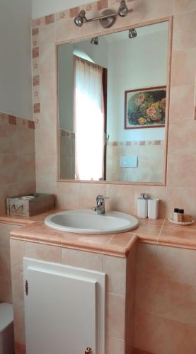 a bathroom with a sink and a mirror at La Casa Tra Gli Ulivi in Cortona