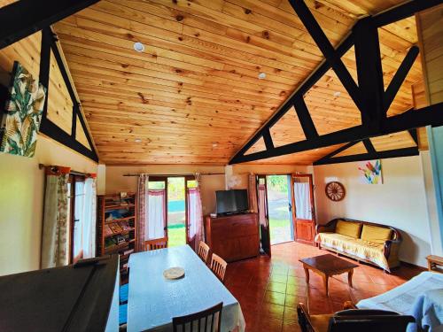 Chalet Combava في سانت بندويت: غرفة معيشة بسقف خشبي وطاولة