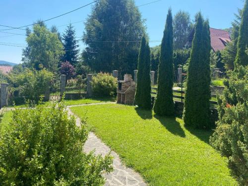 un jardin avec des arbres et de la pelouse ainsi qu'une clôture dans l'établissement Casa de Vacanta Mountain View, à Cheia