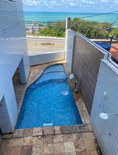 una piscina en un edificio con vistas al océano en Ponta negra Flat, en Natal
