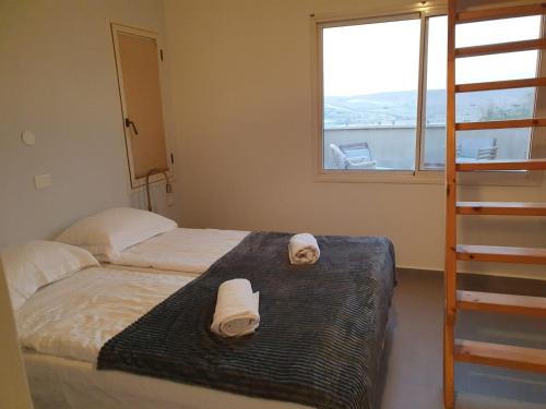 a bedroom with two beds with towels on the bed at שקיעות מדבר in Yeroẖam