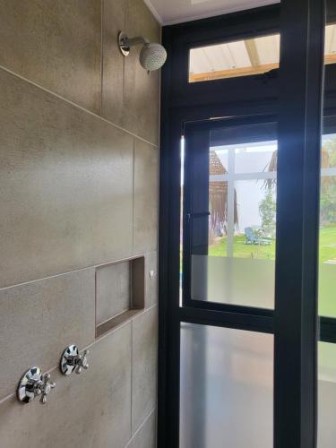 a bathroom with a shower with a glass door at The tiny home in Riebeek-Wes