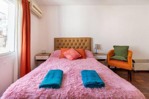 1 dormitorio con 1 cama rosa y 2 almohadas en Disfruta Recoleta desde este tranquilo Monoambiente en Buenos Aires