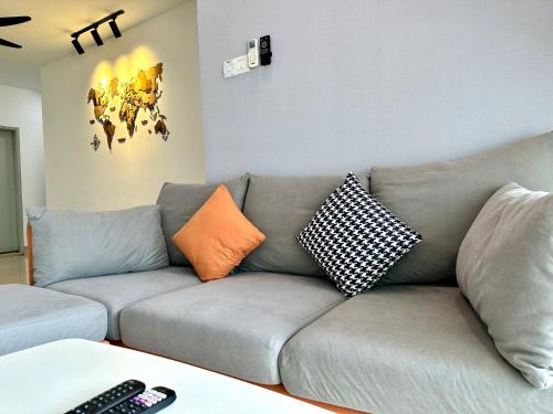 a living room with a gray couch with pillows at IJM Condo with Pool #Yoyo Homestay in Sandakan