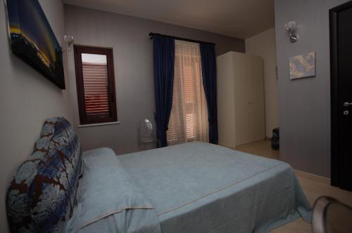 a bedroom with a bed and a window at Regalpetra Hotel in Racalmuto