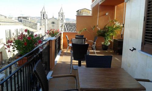 a balcony with tables and chairs on a building at Regalpetra Hotel in Racalmuto