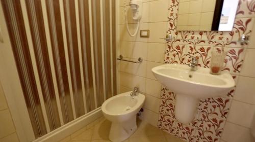 a bathroom with a sink and a toilet at Regalpetra Hotel in Racalmuto