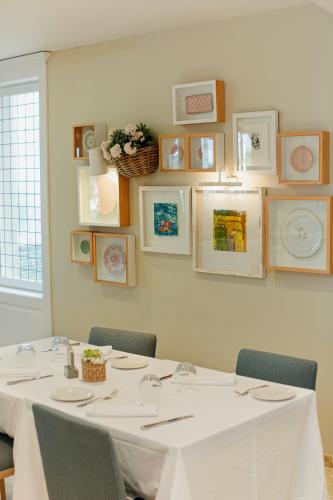 a room with a table with chairs and pictures on the wall at Hotel Los Ángeles Denia in Denia
