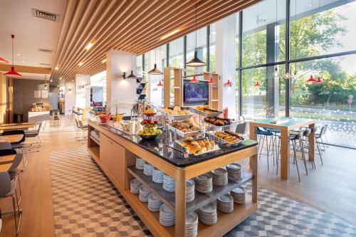 a breakfast buffet in a restaurant with tables and chairs at Holiday Inn Express Porto Exponor, an IHG Hotel in Leça da Palmeira